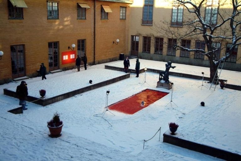 Dans un square enneigé, un rectangle rouge au sol