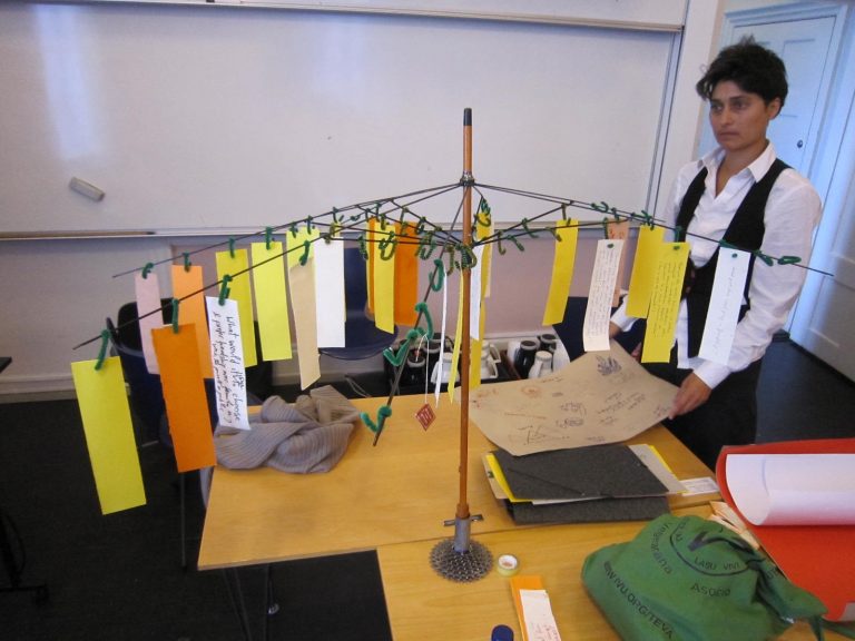 Oeuvre composée d'une structure à laquelle sont attachés des petits papiers